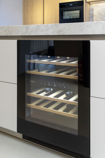 Greeploze wijnklimaatkast met glazen deur en houten lades, perfect geïntegreerd in een maatwerkkeuken