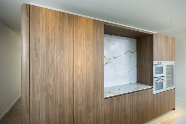 Moderne keuken met notelaar fronten en Silestone Versailles Ivory nis uit de Le Chic Collection