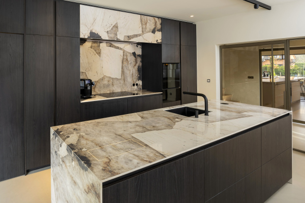 Modern keukeneiland in keramiek Desert Soul met geïntegreerde spoelbak en zwarte accenten
