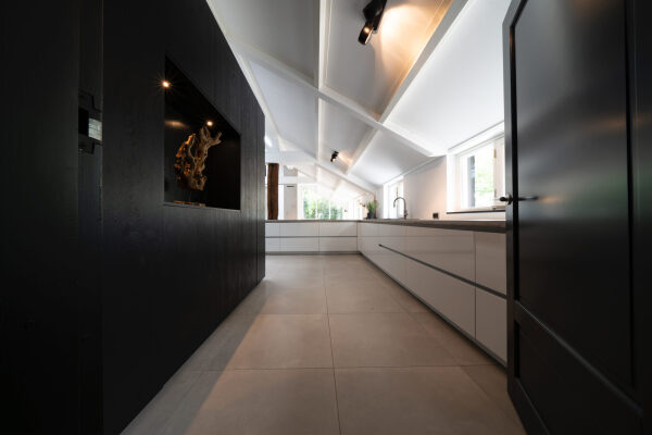 Keuken met strakke lijnen, acryl mat witte fronten en donkere wandkast