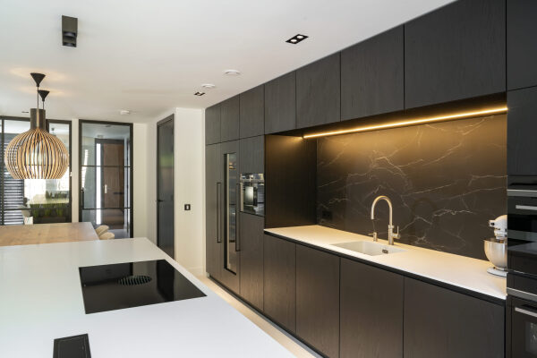 Keuken met eiken fineer en Fenix Angola, uitgerust met Quooker Flex RVS Combi+ kraan en een naadloos Corian werkblad